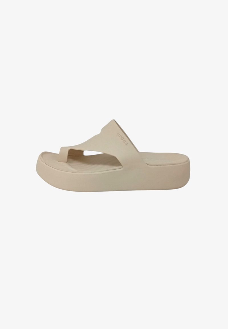 Sandal in beige a infradito con una suola spessa e testurizzata, design minimalista e un cinturino superiore a forma di V. Materiale liscio con un marchio discreto.