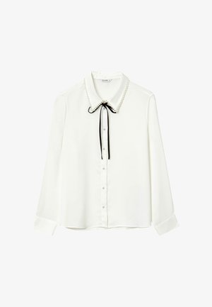 White long-sleeve blouse with pearl-trimmed collar, black ribbon bow, pearl buttons down the front, and buttoned cuffs.