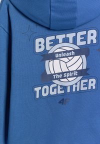 Sweat à capuche bleu avec un motif de volley-ball et les mots « Better Together » et « Unleash The Spirit » imprimés dans le dos.