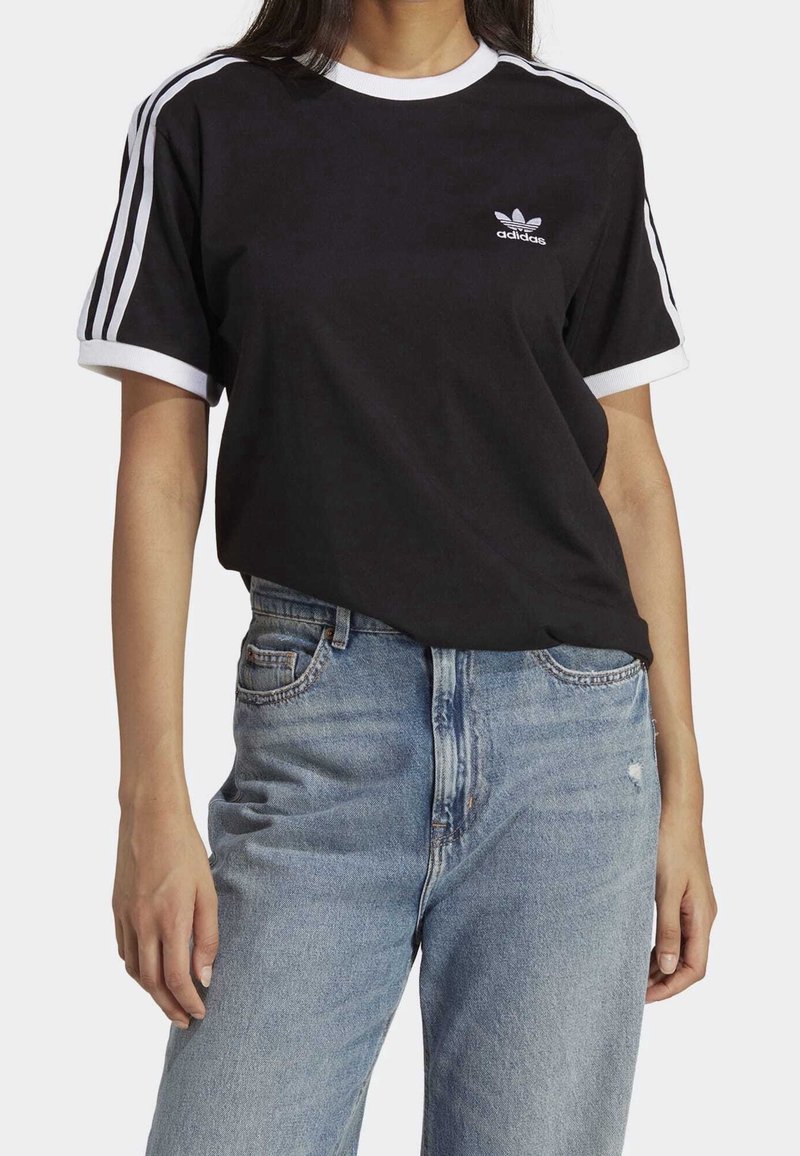 Černé bavlněné tričko s bílým límečkem a manžetami, s třemi bílými pruhy na rukávech a malým logem Adidas na hrudi.