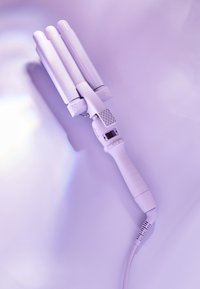 Fer à friser triple baril blanc avec une prise texturée, un affichage numérique et des réglages de température ajustables. Barils lisses et brillants.