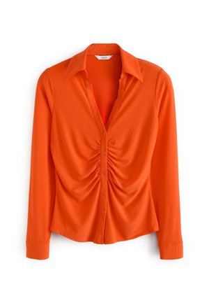 Blouse à manches longues orange vif avec devant froncé, fermeture par boutons, col pointu et poignets ajustés, présenté sur un fond blanc.