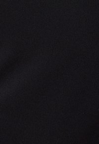 Tissu élastique noir avec une texture côtelée, présentant une finition lisse et un léger brillant. Aucune motif visible ni détails matériels.