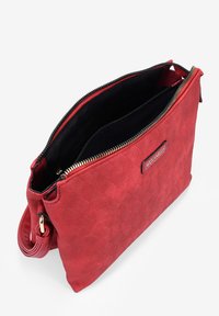 Bolso de mano tejido rojo con cierre de cremallera, que cuenta con un forro interior negro, herrajes dorados y una placa con el logo en el lateral.