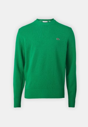 Maglione verde a maglia con collo a coste e orlo, caratterizzato da un piccolo logo ricamato sul petto. Realizzato in un tessuto morbido e strutturato.