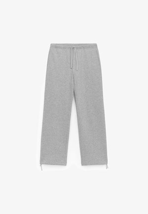 Szare dresy wykonane z miękkiego materiału, z elastycznym paskiem w talii z sznurkiem, prostymi nogawkami i subtelnymi związkami przy kostkach.