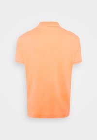 Polo orange à texture douce, manches courtes et col classique. La vue de dos montre une couleur uniforme et lisse.