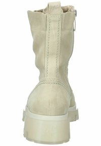 Stivaletti alla caviglia in suede beige con un design leggermente sfinato, zip sul retro, cuciture a contrasto e una spessa suola platform bianca.