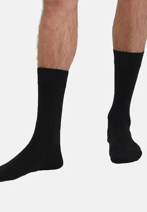 Schwarze Crew-Socken aus einem weichen, dehnbaren Material, mit einem gerippten Bündchen, glatter Textur und klassischem Design.