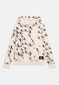 Béžová mikina s opakujícím se černým logem na přední straně. Měkká látka, dlouhé rukávy a kapuce s žebrovaným lemem.