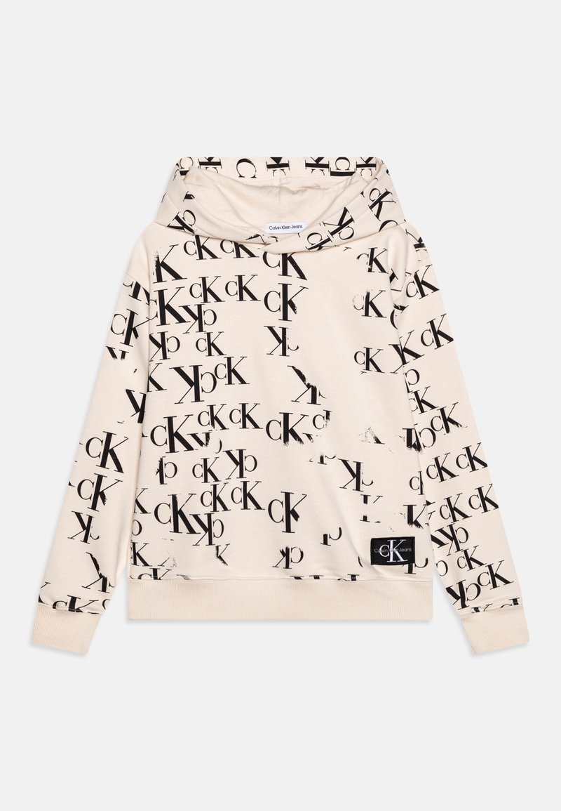 Béžová mikina s opakujícím se černým logem na přední straně. Měkká látka, dlouhé rukávy a kapuce s žebrovaným lemem.