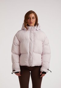 Dik lichtroze jack met een hoge kraag, een ritssluiting aan de voorkant en een trekkoordkap. Heeft elastische manchetten en een logodetail op de mouw.