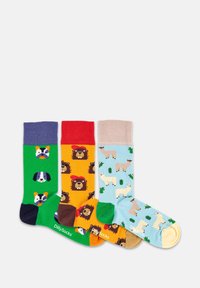 Cuatro pares de calcetines coloridos con patrones de animales: verdes con perros, naranjas con leones, beige con llamas y azul claro con cactus.