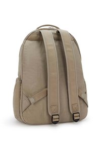 Beige-värinen reppu virtaviivaisella muotoilulla, pehmustetuilla olkahihnoilla ja yläkahvalla. Siinä on sivutaskut ja säädettävät sulkemiset.