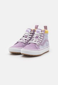 Zapatillas altas en ante lavanda y gris, con suela de goma blanca, cordones blancos y acentos amarillos en el cuello y la lengüeta.