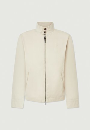 Chaqueta beige con un cuello alto, cierre frontal, dos bolsillos laterales y un logotipo sutil en el pecho. Tejido suave con un diseño estructurado.