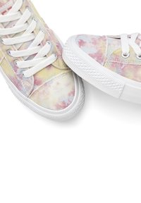 Canvas sneakers featuring a tie-dye pattern in pastel colors of pink, yellow, and blue, with white laces and rubber soles.
