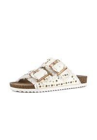 White fabric slide sandals featuring two adjustable buckles, frayed edges, metallic studs, and a textured brown cork footbed.