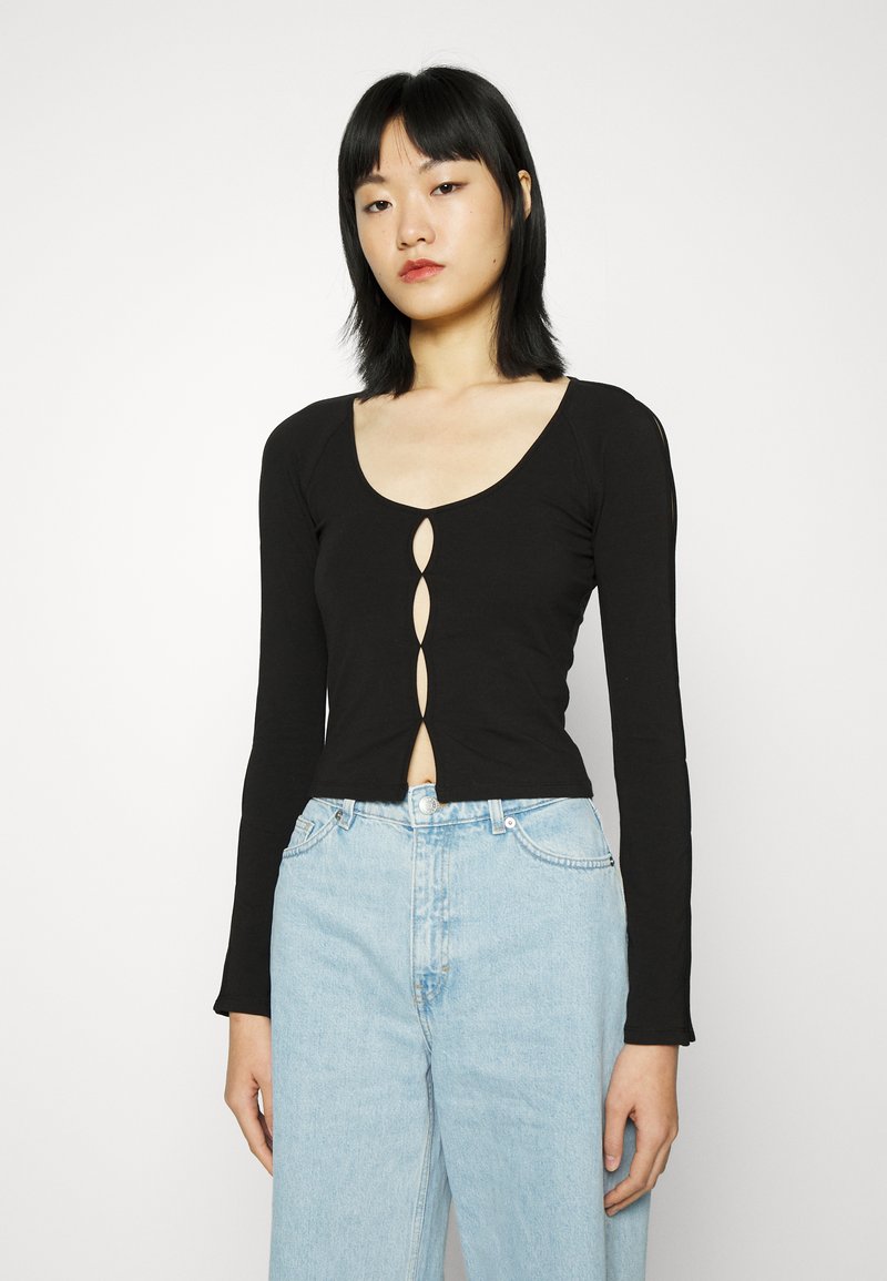 Top preto de manga longa com decote em forma de coração e detalhe de fecho com cinco botões na parte da frente. Tecido macio e elástico; design just fitted.