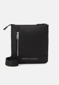 Crna kožna torbica preko tijela s teksturiranom površinom, zatvaranjem na patentni zatvarač, podesivim remenom i urezanim logotipom "Armani Exchange" sprijeda.