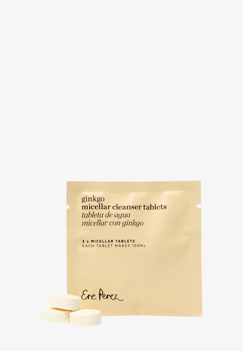 Trois comprimés blancs de nettoyant micellaire empilés à côté d'un paquet beige étiqueté "comprimés nettoyants micellaires ginkgo" par Ere Perez.