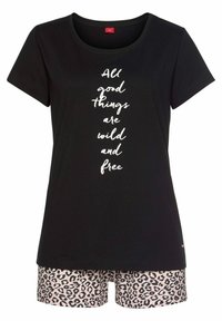 Zwarte T-shirt met korte mouwen en witte tekst "Alle goede dingen zijn wild en vrij", gecombineerd met lichtroze shorts met een luipaardprint.