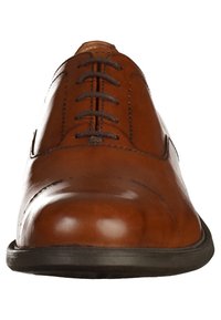 Chaussure oxford en cuir marron avec lacets noirs, détail de brogue léger et semelle en caoutchouc noir, vue de face.