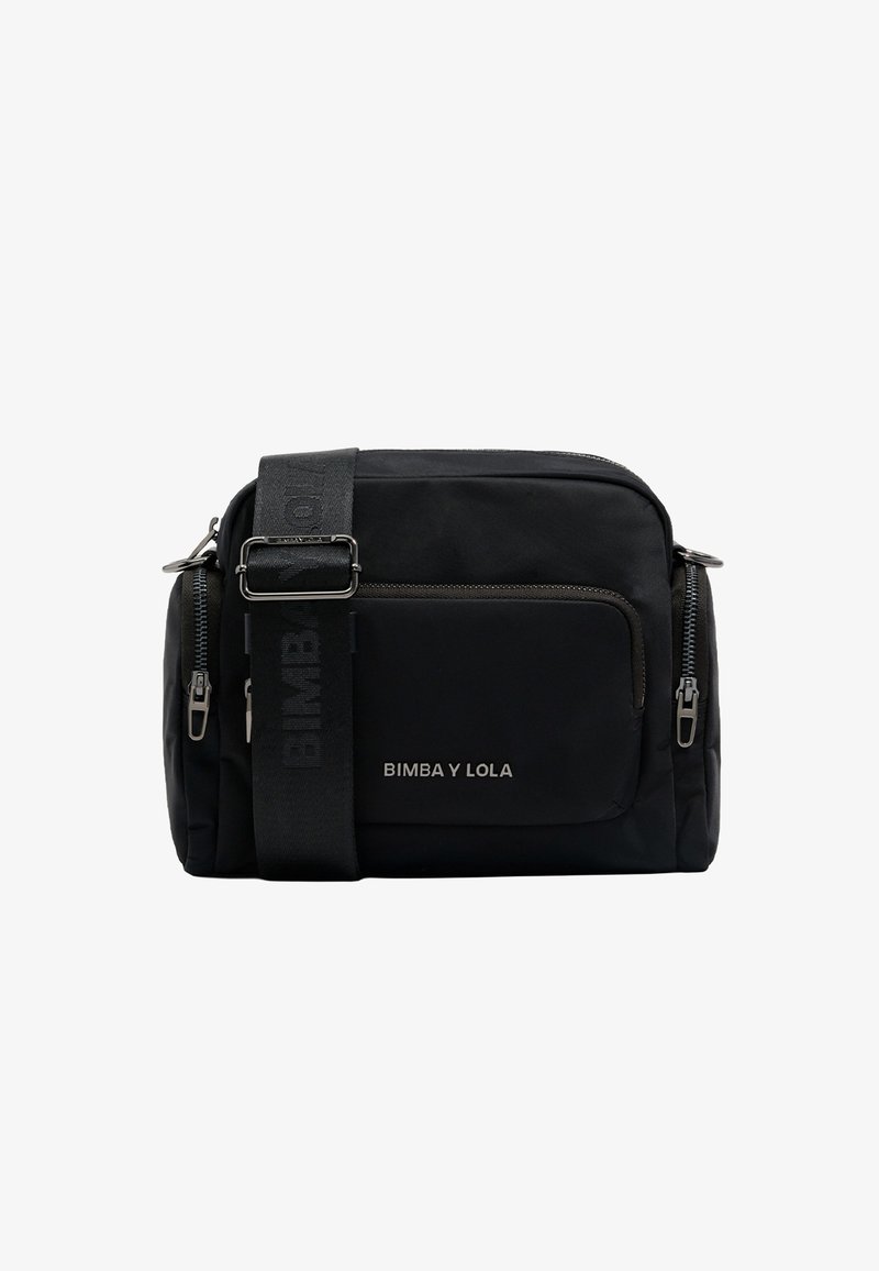 Mustast nailonist valmistatud ristkeha kott, millel on eesmine lukuga tasku, reguleeritav rihm logoga ja hõbedased seadmed. Minimalistlik disain.