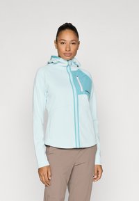 Ανοιχτό μπλε μπουφάν με φερμουάρ και κουκούλα, με τσέπη στο στήθος σε τιρκουάζ και φερμουάρ σε ανοιχτό ροζ, κατασκευασμένο από λείο, ελαστικό ύφασμα.