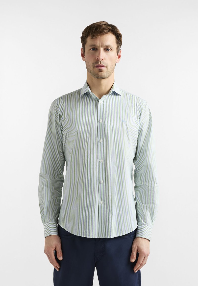 Chemise boutonnée bleu clair avec des rayures verticales vertes et bleu foncé, manches longues, col pointu. Tissu à la texture douce.