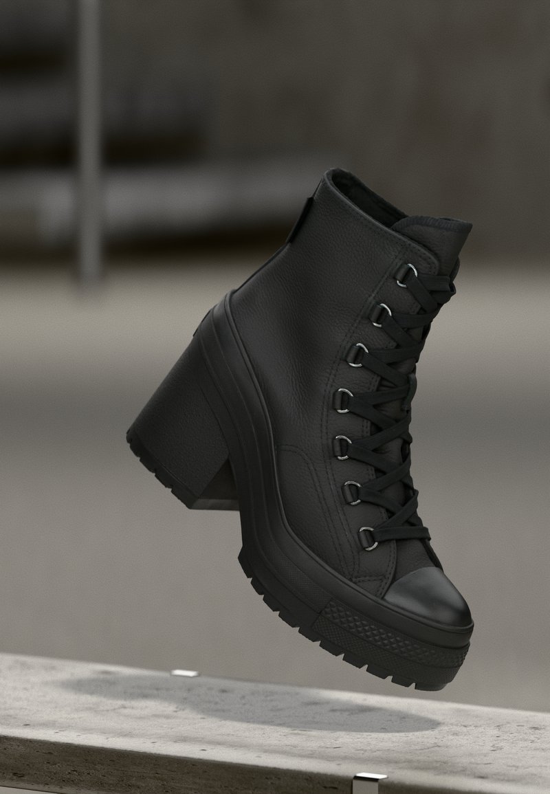 Sorte high-top platform støvler med en struktureret læderoverflade, snøring fortil og kraftig hæl. Har en gummisål med markante mønstre.