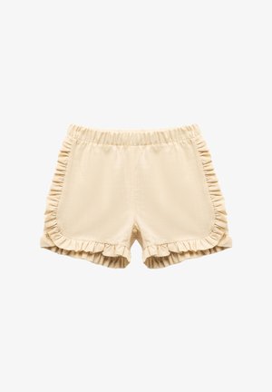 Shorts beiges avec des accents en volants sur les côtés et l'ourlet. Taille élastique pour le confort. Texture lisse avec un tissu léger.