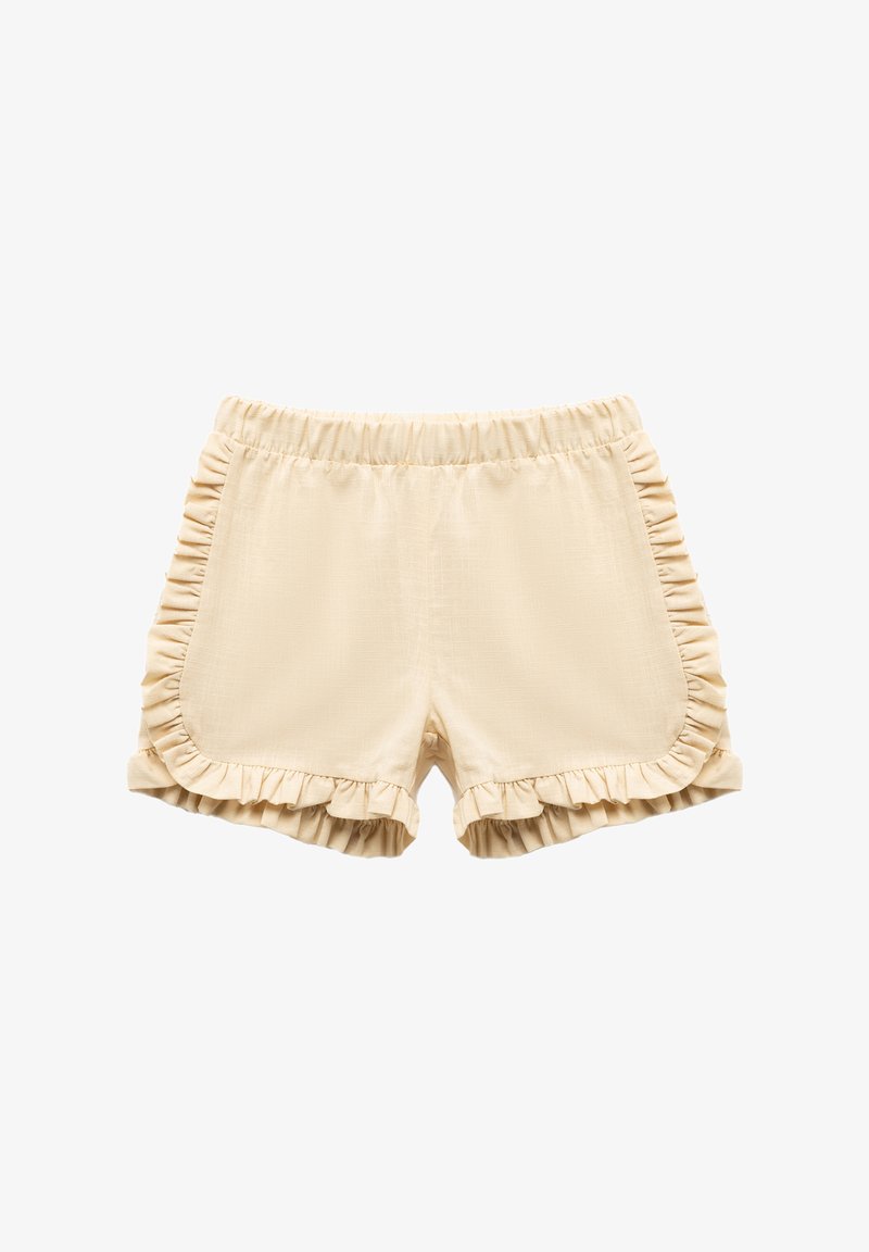Beige shorts with ruffle accents along the sides and hem. Elastic waistband for comfort. Smooth texture with a lightweight fabric.