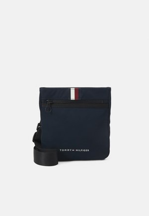 Borsa a tracolla in nylon blu navy con una tasca con zip orizzontale, dettaglio a strisce rosse e bianche nella parte superiore e logo del brand sul fronte.