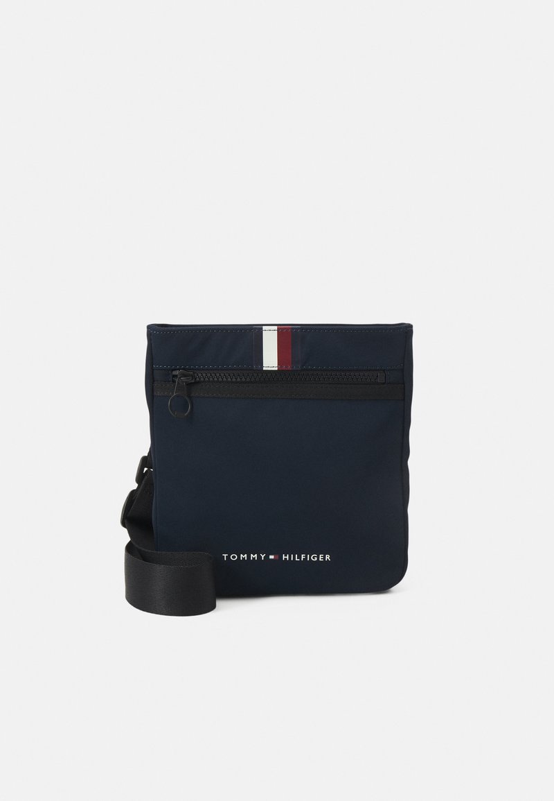 Borsa a tracolla in nylon blu navy con una tasca con zip orizzontale, dettaglio a strisce rosse e bianche nella parte superiore e logo del brand sul fronte.
