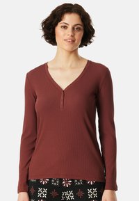 Bordaux langemouwen shirt met een V-hals en knoopsluiting. Ribbels structuur, slim fit ontwerp, gecombineerd met een gebloemde rok met patroon.