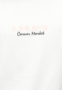 Λευκό ύφασμα με το κείμενο "LYLE'S" σε ανοιχτό πορτοκαλί πάνω από το "Corner Market" με μαύρα γράμματα σε στυλ γραφής.