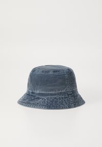 Sötétkék kordbársony búka sapka, henger alakú, széles, lefelé hajló peremmel. Finom textúrájú mintázat jellemzi.
