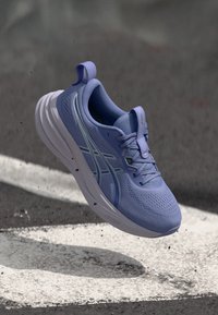 Hele lilla kerge treeningujalats hingava kootud pealse, valge keskosa ja silmapaistva paeltega süsteemiga. Omab peeneid aktsentjooni.