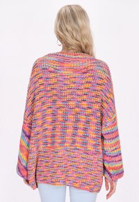 Pulover tricotat supradimensionat multicolor, cu modele în nuanțe de roz, mov și albastru, cu mâneci largi și un material texturat. Vedere din spate prezentată.