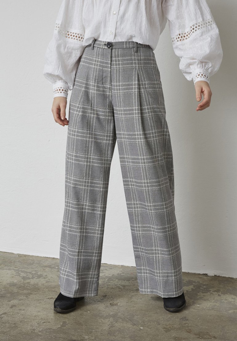 Gråternet bukser med høj talje, bred ben-design og knaplukning. Stoffet har en glat tekstur med kontrasterende hvide linjer.