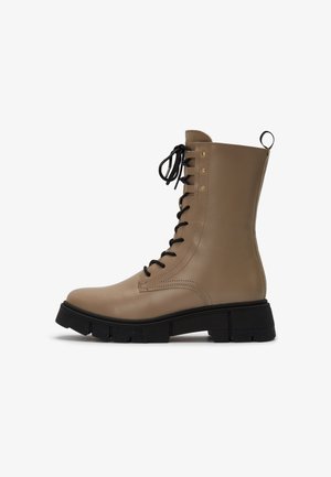 Beige leather combat boot with black thick sole, black laces, and a pull tab at the back, shown in side profile on a white background.