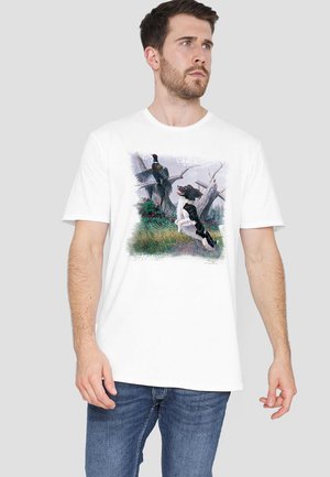 Weißes Baumwoll-T-Shirt mit einer Illustration eines Vogels und eines Hundes in einer natürlichen Umgebung. Rundhalsausschnitt, kurze Ärmel, lässige Passform.