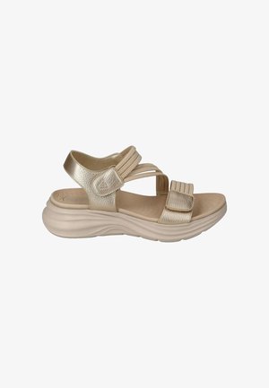 Beige gevoerde sandaal met verstelbare bandjes en een dikke golvende zool, ontworpen voor comfort en casual gebruik.