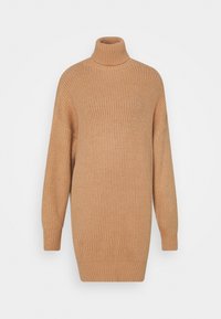 Turtleneck-tröja i beige med en ribbad textur, lös passform och lång ärm som avsmalnar vid manschetterna.