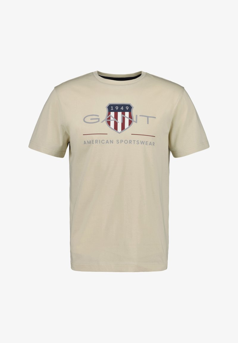 Hellbeige Baumwoll-T-Shirt mit kurzen Ärmeln, rundem Halsausschnitt und einem blau-roten Logo mit Streifen und dem Text "GANT 1949 AMERICAN SPORTSWEAR."