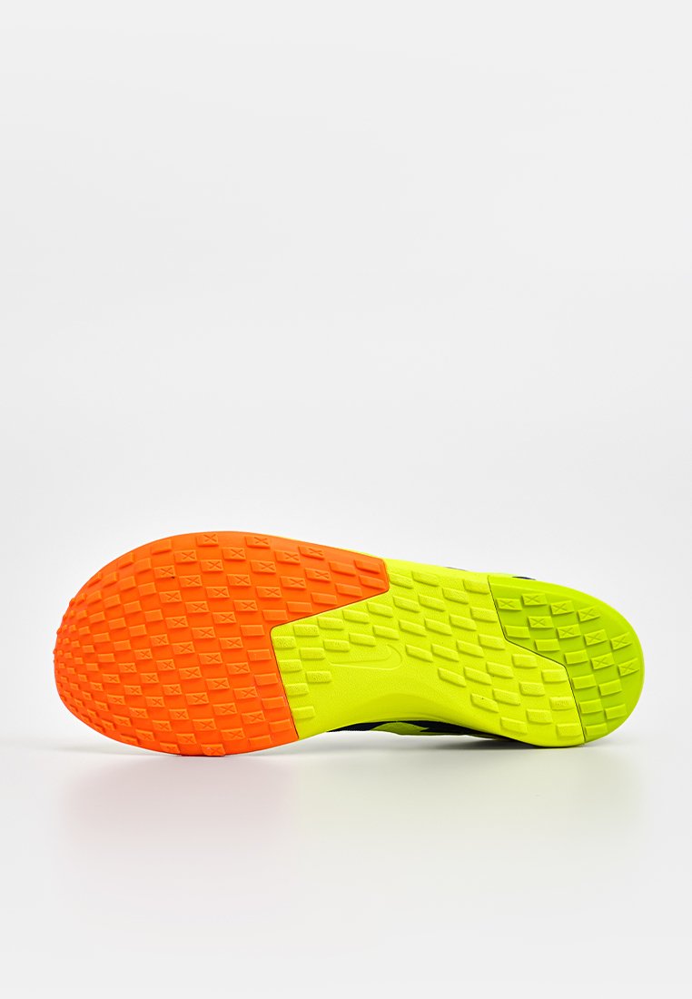 Suola della scarpa con un design testurizzato, caratterizzata da sezioni arancioni e verde brillante. La superficie presenta un motivo in rilievo per migliorare l'aderenza.