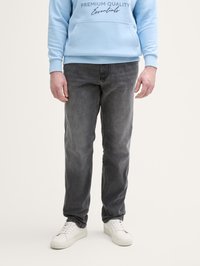 Grijze jeans met een rechte pasvorm, met een subtiele textuur. Gecombineerd met een lichtblauwe hoodie en witte sneakers. Minimalistisch ontwerp.