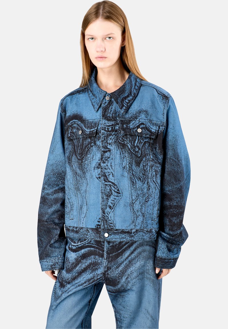 Giacca di jeans con un design blu e nero sfumato, dotata di due tasche sul petto, chiusura a bottoni e colletto classico. Finitura testurizzata.