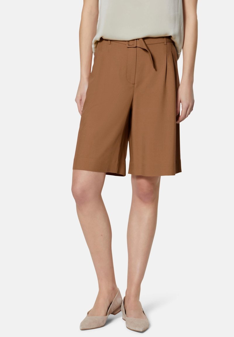 Bruine op maat gemaakte shorts met een tailleband, een relaxte pasvorm en een gladde textuur. Gestyled met een licht topje en beige schoenen.